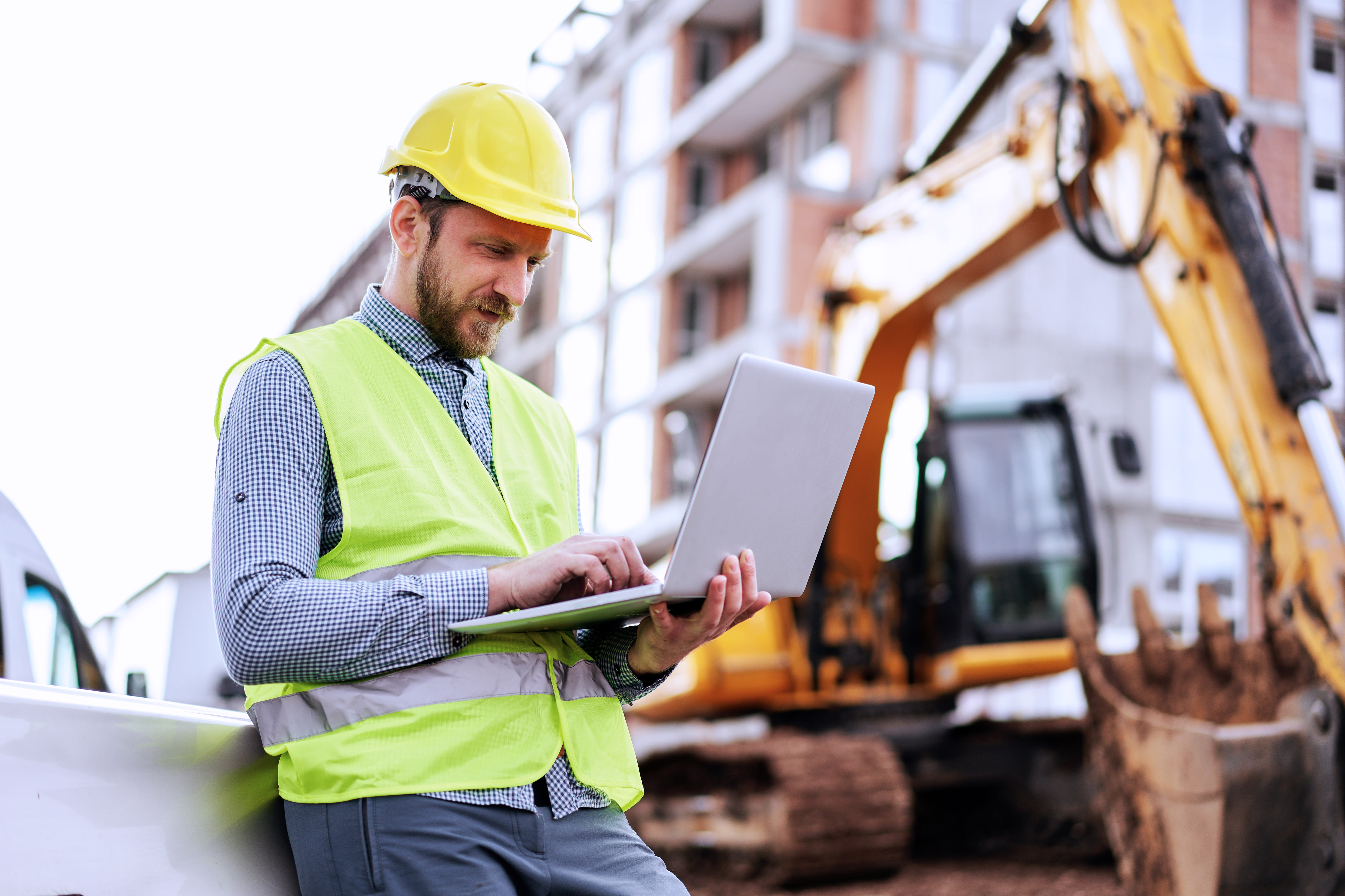 Image of a construction worker on his laptop.